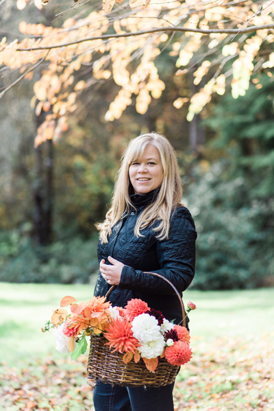 Alicia Schwede of Bella Fiori holding an arrangement of dahlias from the garden.